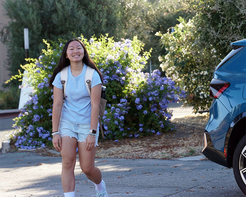 a female student smiles after being dropped off at AEON School in Silicon Valley